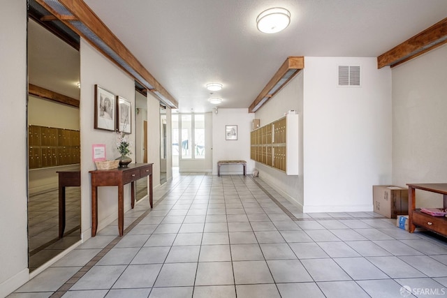 hallway featuring light tile patterned floors and mail boxes