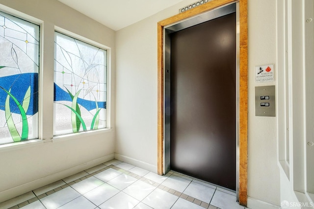 interior space featuring elevator and light tile patterned floors