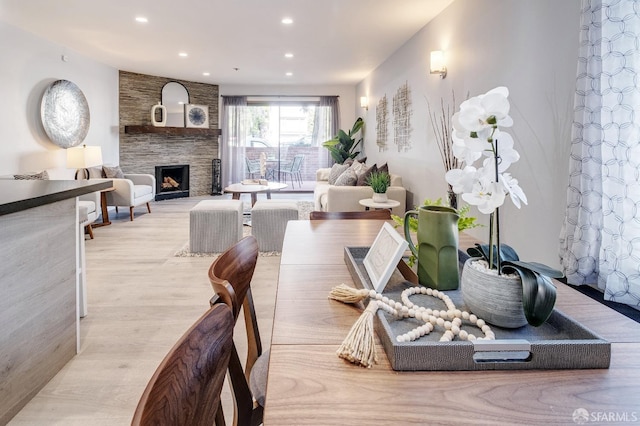 dining space with a fireplace and light hardwood / wood-style floors