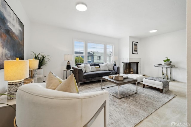 living room with a multi sided fireplace and carpet