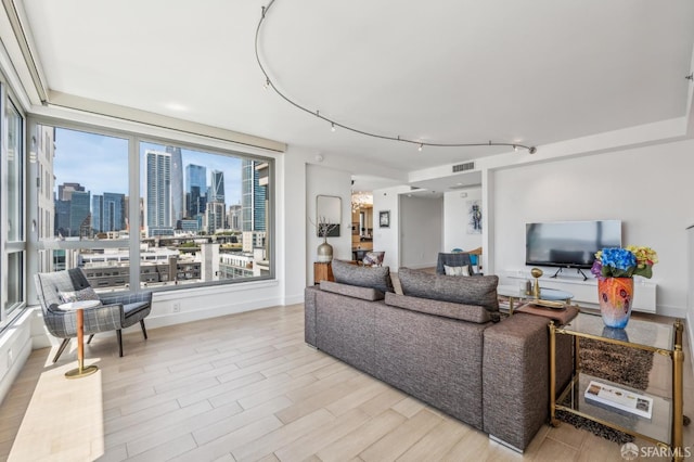229 Brannan St Unit 11J, San Francisco, CA 94107 - living room with a city view, light wood-style floors, and rail lighting
