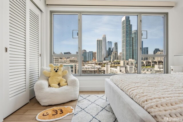 229 Brannan St Unit 11J, San Francisco, CA 94107 - bedroom with a view of skyline and wood finished floors