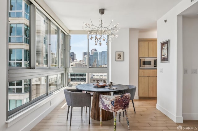 229 Brannan St Unit 11J, San Francisco, CA 94107 - dining room with a chandelier, light wood finished floors, baseboards, and a skyline view