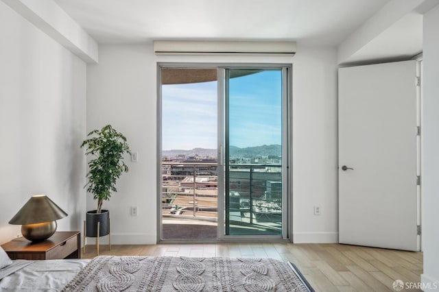 229 Brannan St Unit 11J, San Francisco, CA 94107 - bedroom featuring access to outside, wood finished floors, a mountain view, and baseboards
