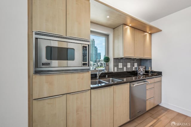 229 Brannan St Unit 11J, San Francisco, CA 94107 - kitchen featuring light brown cabinets, stainless steel appliances, a sink, light wood-style floors, and decorative backsplash