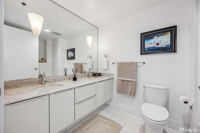 229 Brannan St Unit 11J, San Francisco, CA 94107 - bathroom featuring toilet, tile patterned flooring, double vanity, a shower, and baseboards