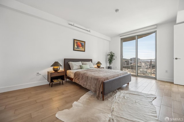 229 Brannan St Unit 11J, San Francisco, CA 94107 - bedroom featuring access to exterior, light wood finished floors, and baseboards