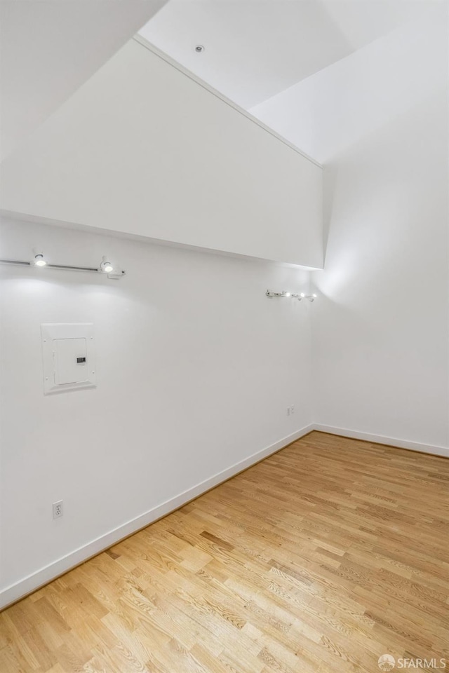 empty room featuring light wood-type flooring and electric panel