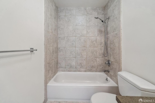 bathroom featuring tiled shower / bath combo and toilet