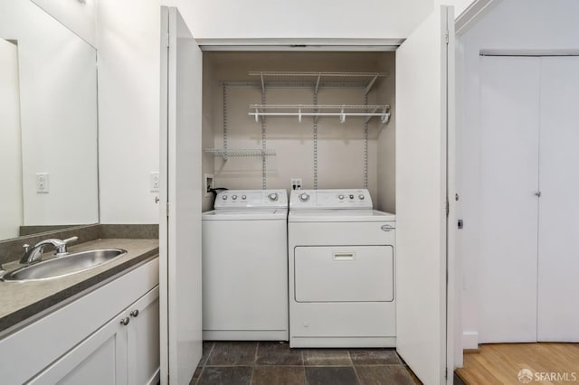 clothes washing area with dark hardwood / wood-style flooring, separate washer and dryer, and sink