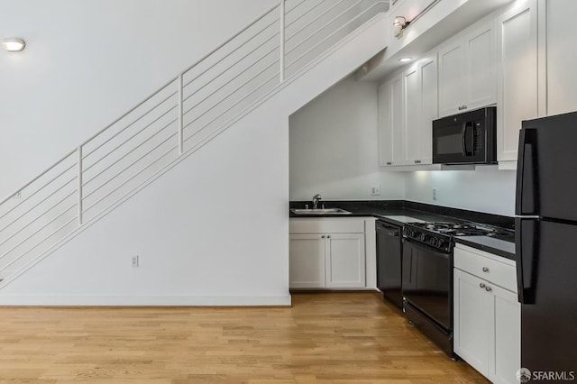 kitchen featuring black appliances, light hardwood / wood-style floors, white cabinetry, and sink