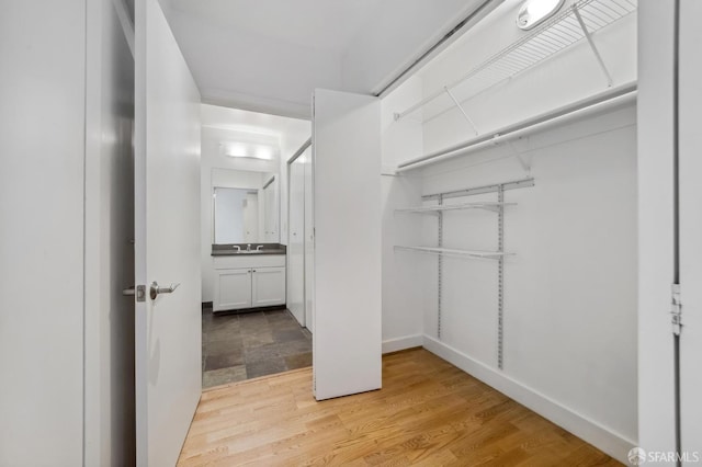 spacious closet featuring light hardwood / wood-style floors and sink