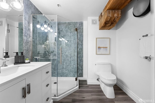 full bathroom featuring vanity, wood finished floors, baseboards, a shower stall, and toilet