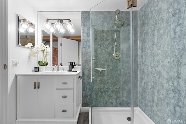 bathroom with vanity, a shower stall, and a notable chandelier