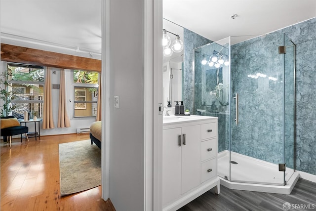 full bathroom featuring a shower stall, vanity, and wood finished floors