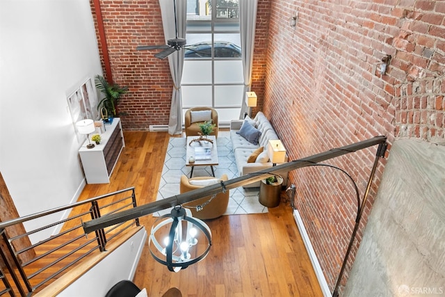 interior space with brick wall and hardwood / wood-style flooring