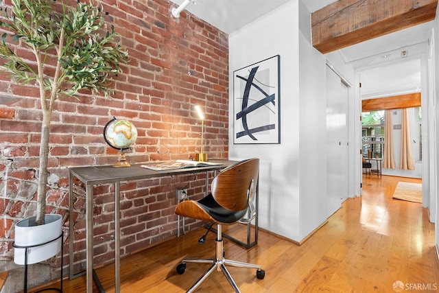 home office featuring hardwood / wood-style floors and brick wall