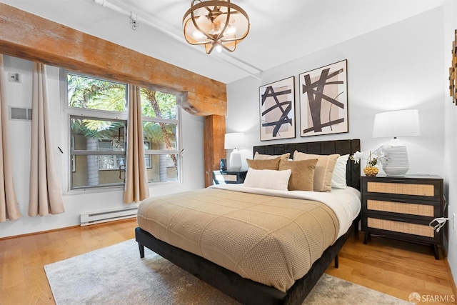 bedroom featuring wood finished floors, a chandelier, and a baseboard radiator