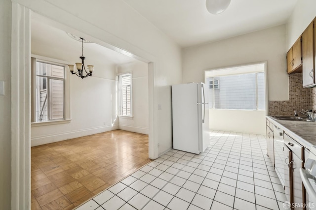 1385-1387 Vallejo St, San Francisco, CA 94109 - kitchen featuring freestanding refrigerator, a sink, a chandelier, tasteful backsplash, and decorative light fixtures