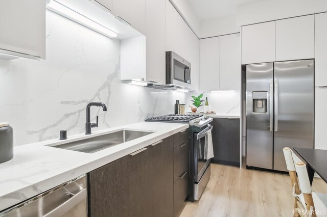 kitchen featuring dark brown cabinets, sink, white cabinetry, and stainless steel appliances