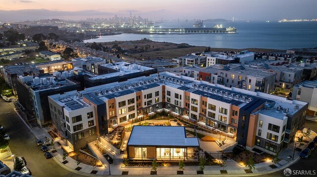 aerial view at dusk featuring a water view