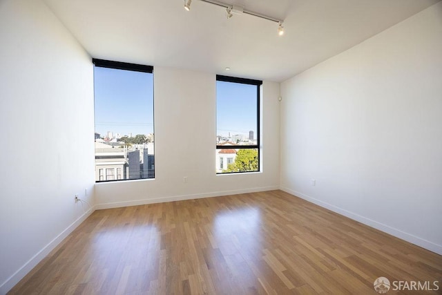 unfurnished room featuring light hardwood / wood-style floors and track lighting