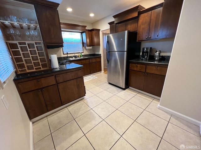 558 A St, Hayward, CA 94541 - kitchen featuring dark countertops, light tile patterned flooring, freestanding refrigerator, and dark brown cabinetry