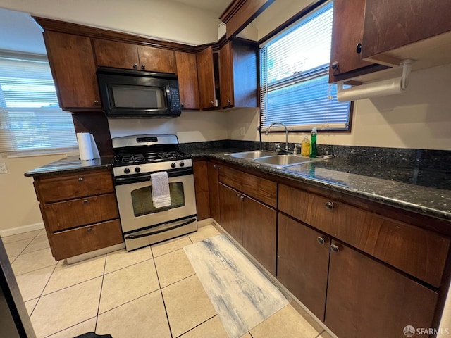 558 A St, Hayward, CA 94541 - kitchen with light tile patterned floors, a healthy amount of sunlight, stainless steel range with gas stovetop, a sink, and black microwave