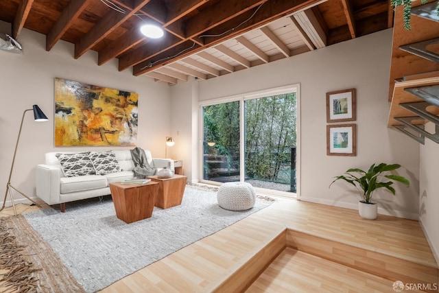 living room featuring beam ceiling, wood ceiling, baseboards, and wood finished floors