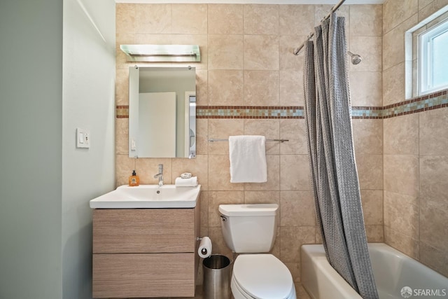 bathroom featuring vanity, toilet, tile walls, and shower / tub combo