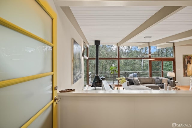 sunroom / solarium with beam ceiling and a wood stove