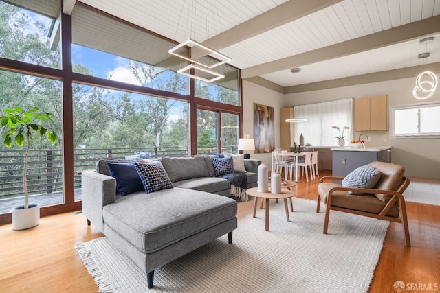 living area featuring light wood finished floors and beamed ceiling