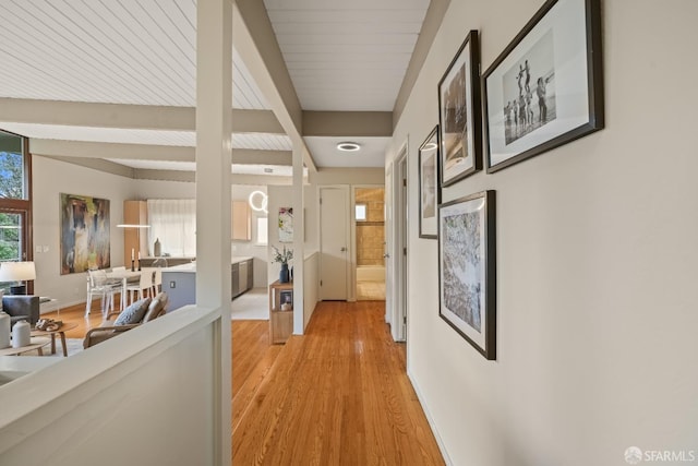 hallway featuring beamed ceiling and light wood finished floors