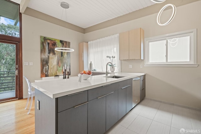 kitchen with light countertops, gray cabinets, and a sink