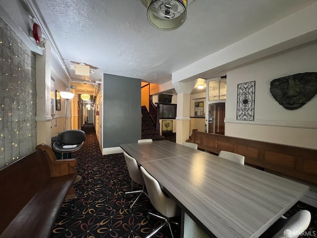 carpeted dining room featuring stairs and a textured ceiling