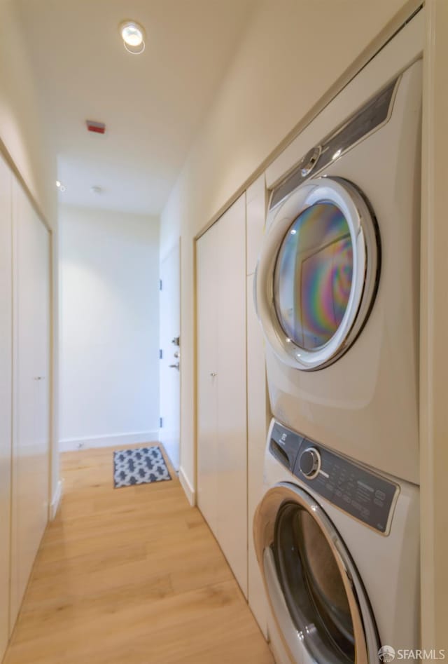 3118 18th St Unit 2, San Francisco, CA 94110 - laundry area with stacked washer / dryer, light wood finished floors, and baseboards