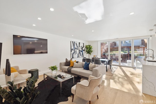 living room with light wood-type flooring and sink