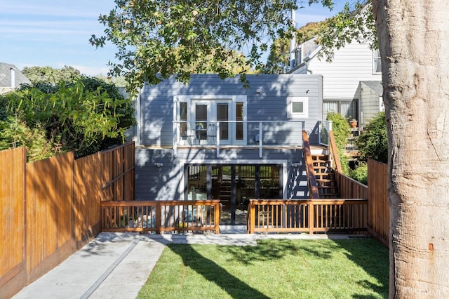 back of house with a lawn and a deck