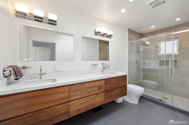 bathroom with vanity, toilet, a shower with door, and tile patterned floors