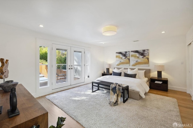 bedroom with access to outside, light wood-type flooring, and french doors