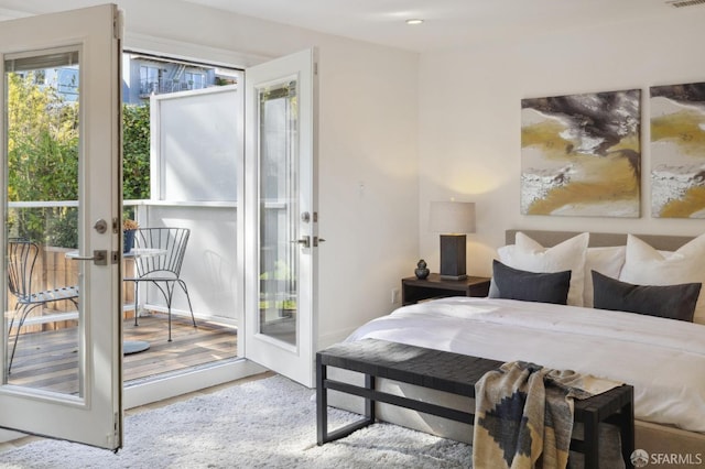 bedroom featuring light hardwood / wood-style flooring, access to exterior, and french doors