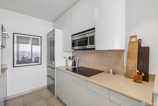 999 Green St Unit 1403, San Francisco, CA 94133 - kitchen with appliances with stainless steel finishes, backsplash, light countertops, white cabinets, and modern cabinets
