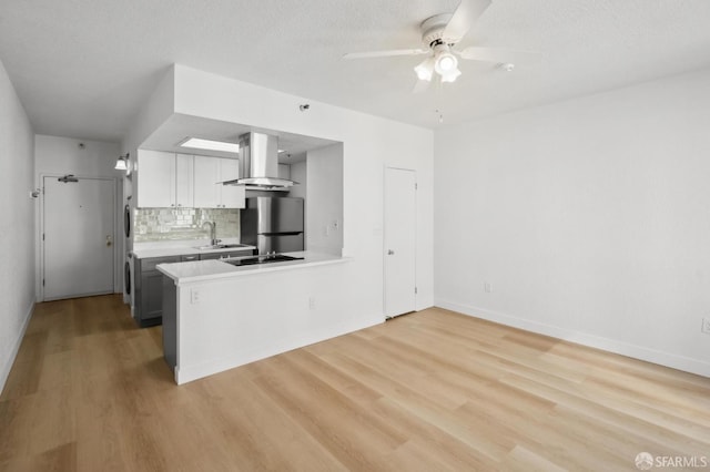 201 Harrison St Unit 302, San Francisco, CA 94105 - kitchen featuring island range hood, ceiling fan, light wood-type flooring, light countertops, and freestanding refrigerator