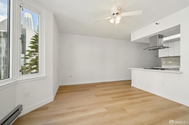 201 Harrison St Unit 302, San Francisco, CA 94105 - unfurnished living room with a baseboard heating unit, a ceiling fan, light wood finished floors, and baseboards