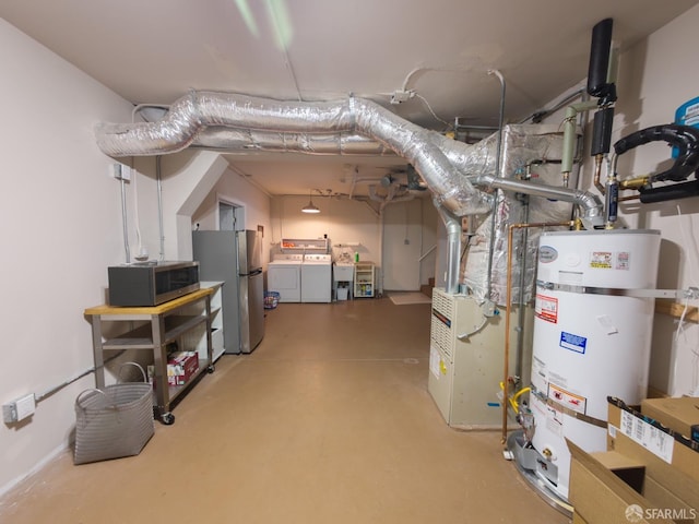 utility room with heating unit, water heater, and washer and clothes dryer