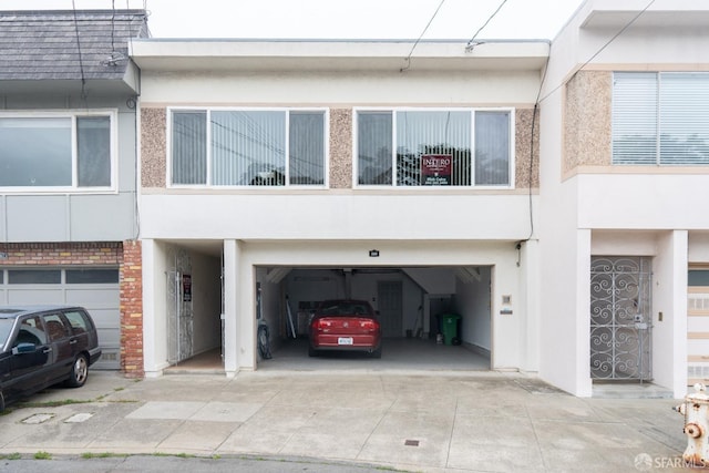 exterior space featuring concrete driveway and stucco siding