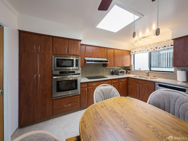 kitchen with appliances with stainless steel finishes, ornamental molding, a sink, under cabinet range hood, and backsplash