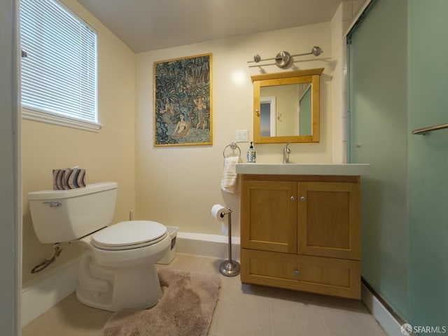 bathroom featuring toilet, an enclosed shower, vanity, tile patterned flooring, and baseboards