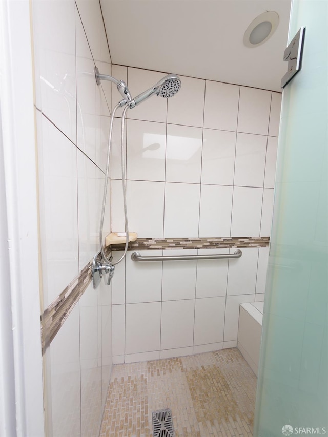 full bath featuring tile walls, visible vents, and tiled shower