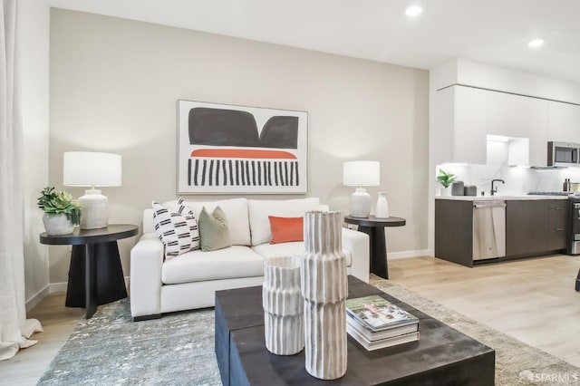 living room with sink and light hardwood / wood-style floors